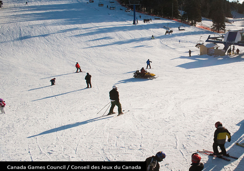 Une piste de ski enneigée avec un télésiège, des skieurs et un planchiste