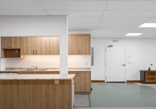 AFTER: Interior of new fire hall. Modern wood and white kitchen with island counter top