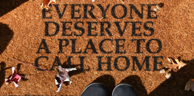 Everyone deserves a place to call home written on a doormat.