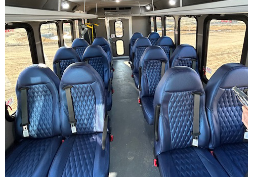 Blue seats in the interior of a bus.